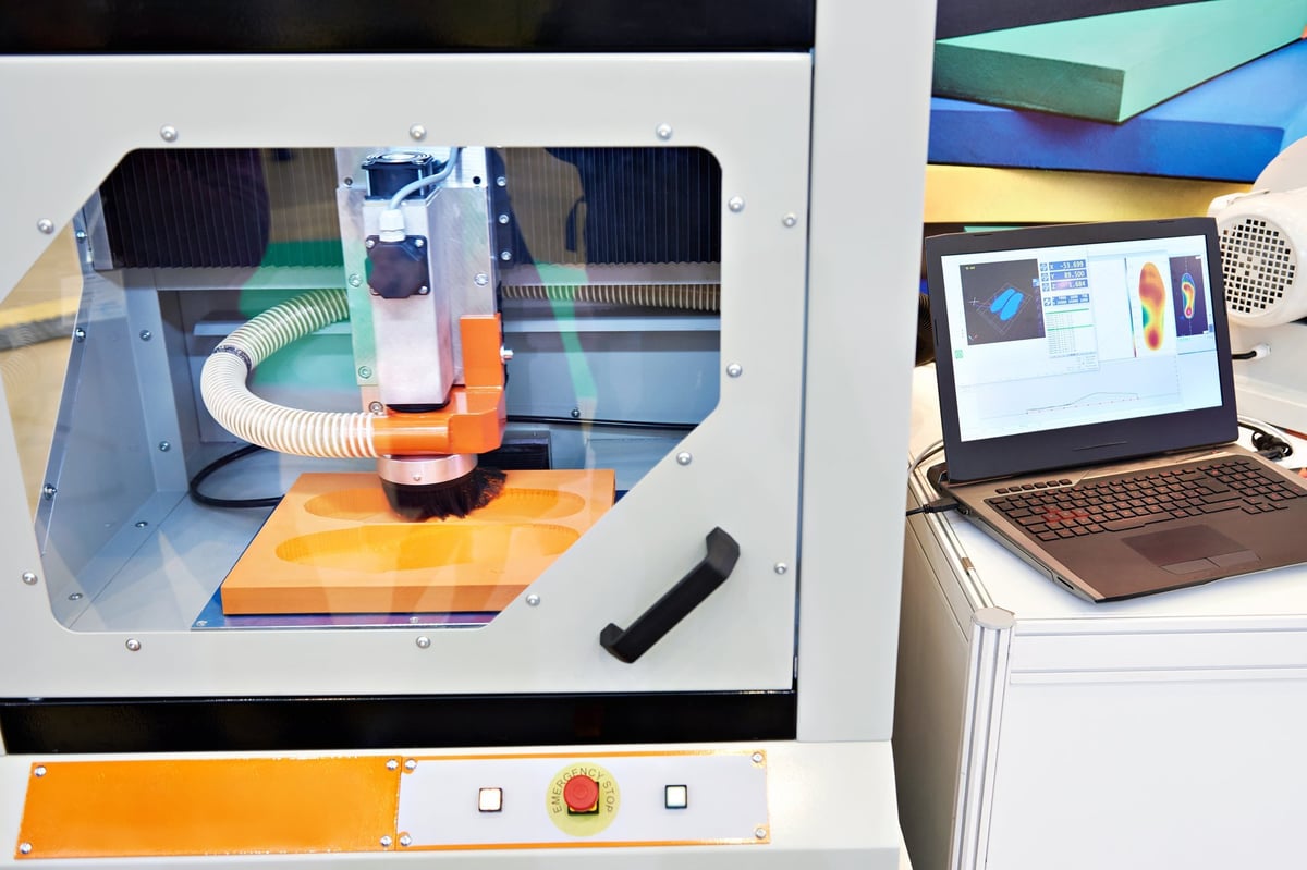 Milling machine shaping a custom orthopedic insole during fabrication