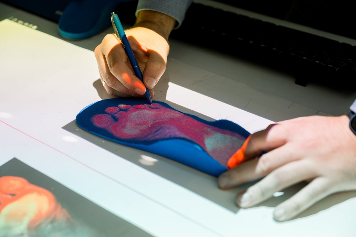 Specialist marking areas on a custom-made orthotic insole during a foot assessment